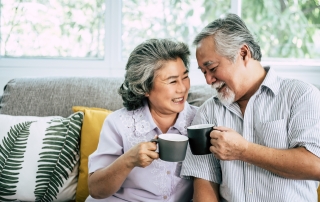 elderly couple talking together drinking coffee milk